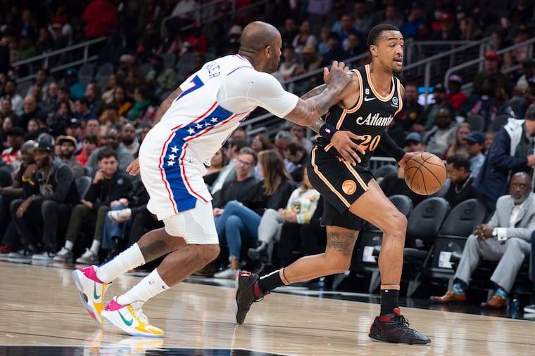 The Atlanta Hawks' John Collins dribbles past Sixers forward P.J. Tucker during a game at State Farm Arena.