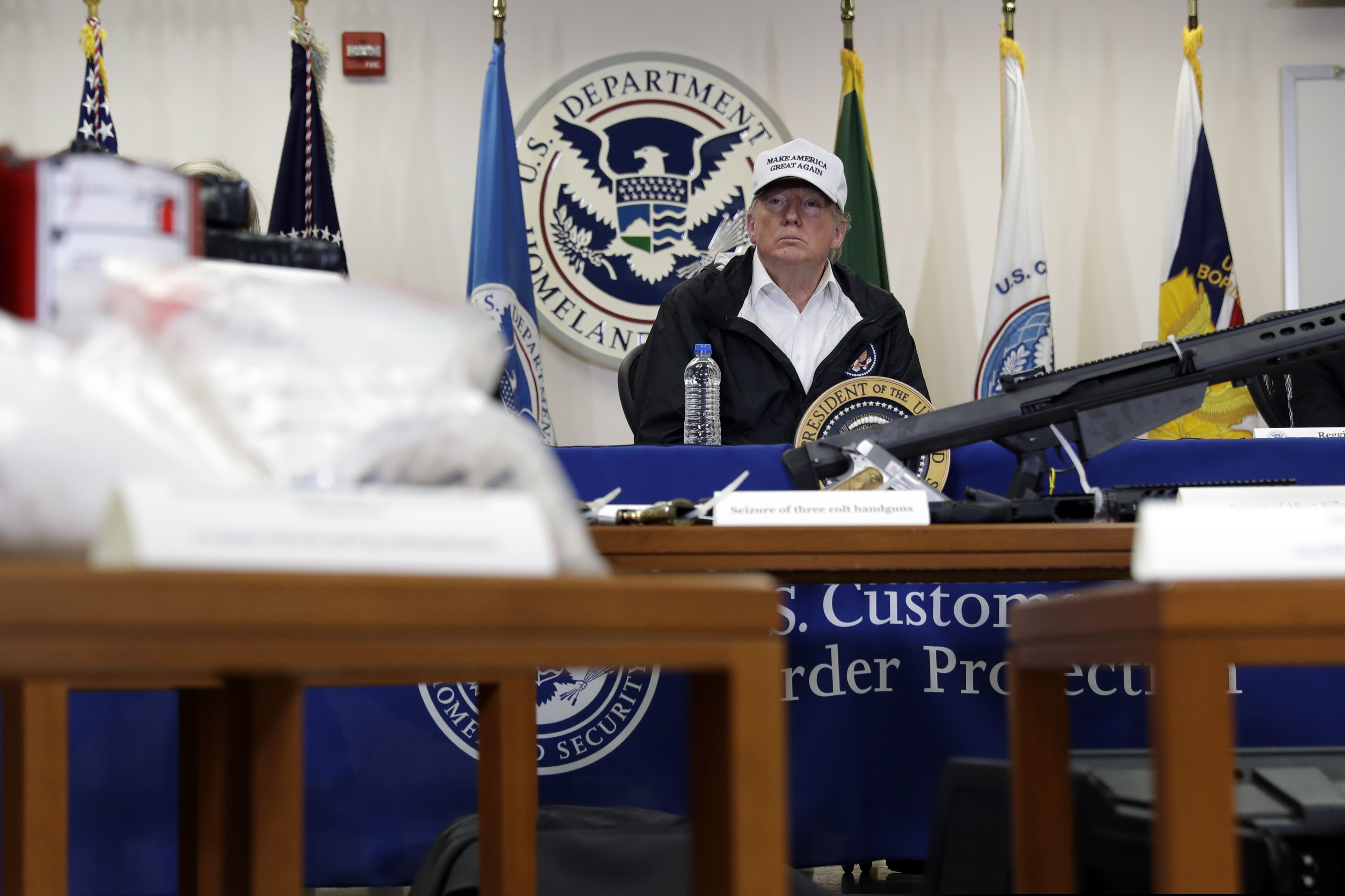 With illegal drugs and weapons displayed in the foreground, President Donald Trump speaks at a roundtable on immigration and border security at U.S. Border Patrol McAllen Station, during a visit to the southern border, Thursday, Jan. 10, 2019, in McAllen, Texas. (AP Photo/ Evan Vucci)