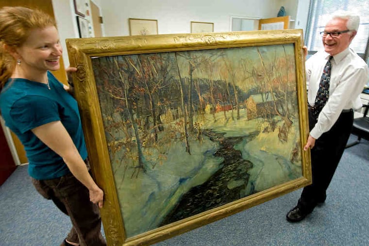 Art teacher Alyce Grunt and Superintendent Joseph Bruni move Walter Emerson Baum's oil painting out of storage. A group bought the painting in the 1930s and presented it to Lansdowne High, now known as Penn Wood High, but students later did not know its history.