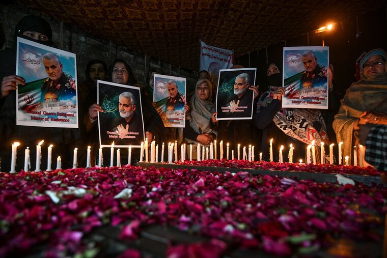 Shiite Muslims hold pictures of slain top Iranian general Qasem Soleimani to pay him tribute during a candle light vigil in Islamabad on Jan. 8.