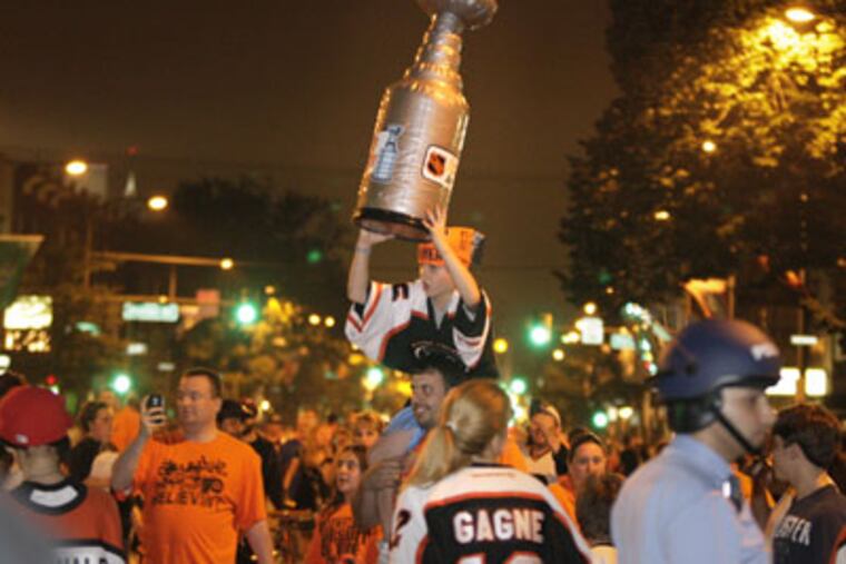 Josh Mac Donald of Phila. holds son Jacob,8, and the Stanley Cup on
Broad St. near Shunk after the Phila. Flyers vs. Montreal Canadiens
game on May 24, 2010. ( Elizabeth Robertson / Staff Photographer )