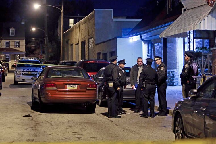 Investigators gather after police found Wayne Robert Ellington Sr. suffering from a gunshot wound inside a car on Marion Street near Queen Lane in the Germantown section of Philadelphia on Sunday Nov. 9, 2014. (For the Daily News/ Joseph Kaczmarek)
