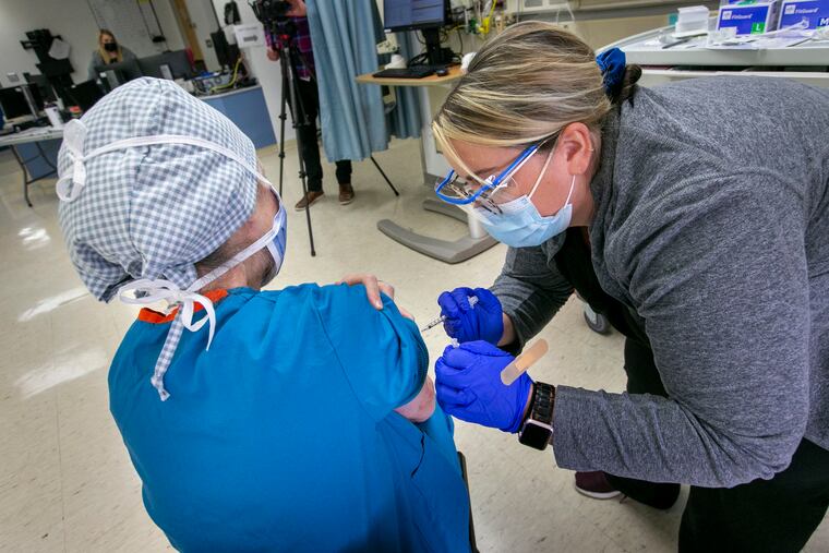 Registered Nurse Erin Gallagher administers the COVID-19 vaccine to Bonnie Karpo, operating room nursing educator, at St. Christopher's Hospital for Children last month.
