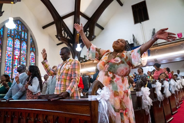Rev. Frantz Ulysse and his wife Fernande Ulysse sing and pray during services at the First Haitian Church of God of Prophecy in Philadelphia on July 12. Many in the congregation are in the country under temporary protected status, which has spared them from deportation.