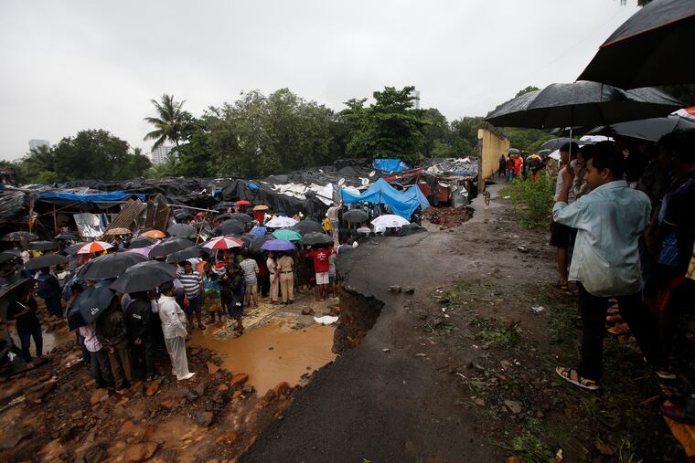 Rescuers and others gather at the spot after heavy rainfall caused a wall to collapse onto shanties, in Mumbai, India, Tuesday, July 2, 2019. More than a dozen people were killed even as forecasters warned of more rains.