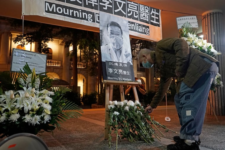 A man wearing mask, attends a vigil for Chinese doctor Li Wenliang, in Hong Kong on Feb. 7. The death of a young doctor who was reprimanded for warning about China's new virus triggered an outpouring Friday of praise for him and fury that communist authorities put politics above public safety.