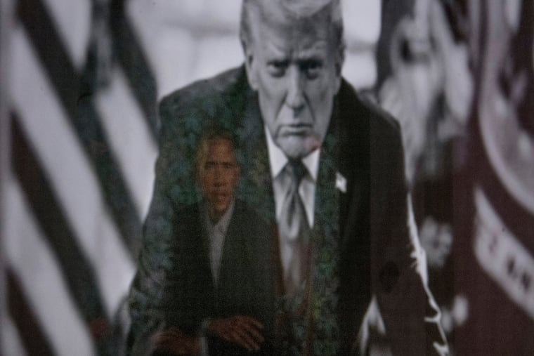 A reflection of the portrait of former President Barack Obama is seen in a photograph of President Donald Trump on display at the Smithsonian's National Portrait Gallery's "American Presidents" exhibit last month in Washington.