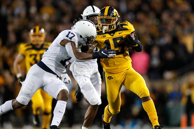 Iowa running back Tyler Goodson (right) runs the ball as he tries to fend off Penn State safety Garrett Taylor (left).