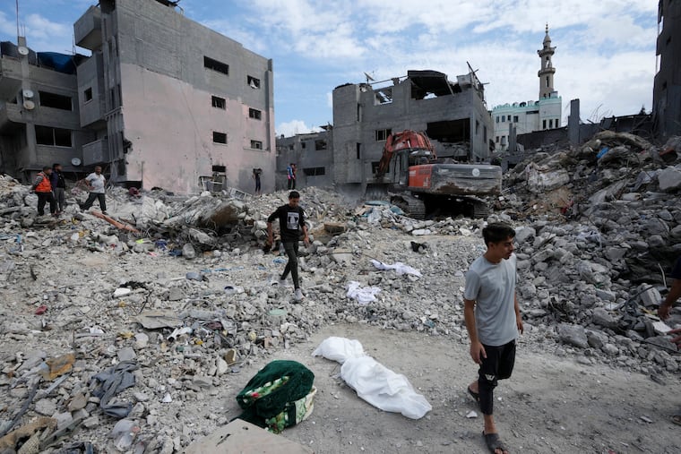 Palestinians recover the bodies of the al Meghari family killed in the Israeli bombardment of the Gaza Strip in Bureij refugee camp, Gaza Strip, on Tuesday, Nov. 14, 2023. U.N. humanitarian monitors say at least 2,700 people, including 1,500 children, are missing and believed buried under the rubble.
