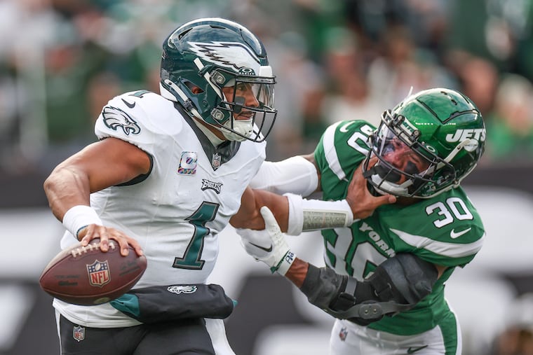 Philadelphia Eagles quarterback Jalen Hurts pushes off New York Jets cornerback Michael Carter II before he throws in the first half of a game at MetLife Stadium.