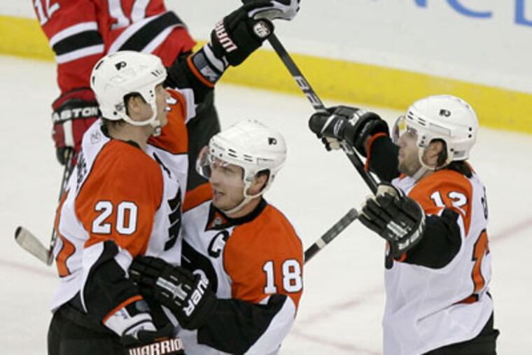 Chris Pronger (left) celebrates game's first goal with Mike Richards (center) and Simon Gagne. (Yong Kim / Staff Photographer)