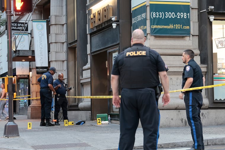 Philadelphia police crime scene investigators gather evidence at the scene of a shooting outside a 7-Eleven convenience store at 12th and Chestnut Streets in September.