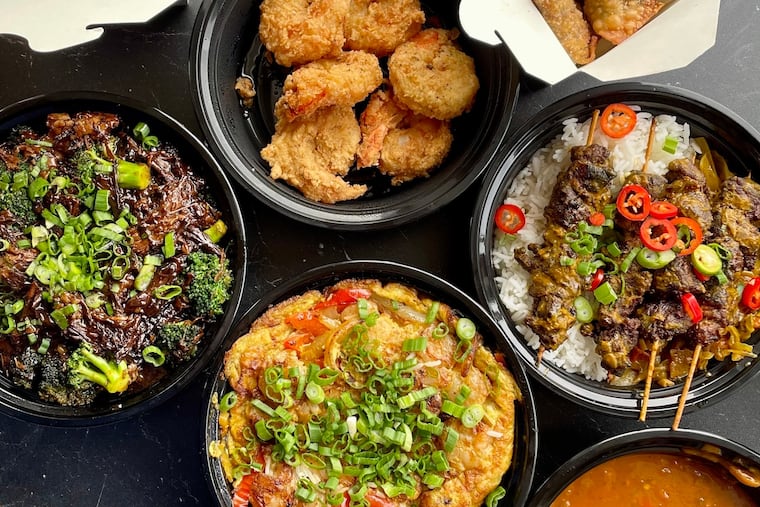 A series of dishes arrayed in the window counter of Black Dragon Takeout, including (clockwise from top left) Man Man lamb noodles, lemon pepper honey fried shrimp; oxtail Rangoon, curried beef skewers, egg wu young with side of crawfish etouffee gravy, oxtail and broccoli.