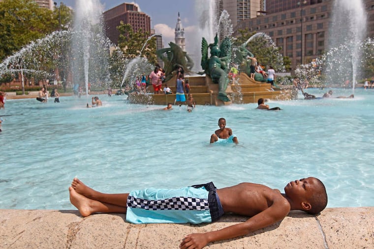 Tyshawn Carter, 9, took a break after cooling off in the Swann Memorial Fountain on a hot day last month. Phila.'s average high temperatures were close to normal.