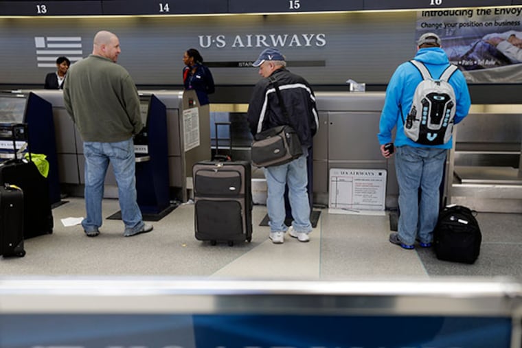 US Airways passengers check in at the ticket counter at Philadelphia International Airport on Feb. 14, 2013, in Philadelphia. (AP File Photo/Matt Rourke)