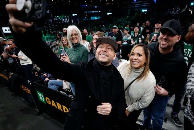 Actor Donnie Wahlberg poses for a selfie with Boston Celtics fans.