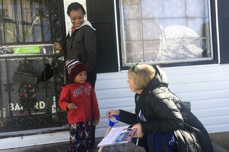 Doug Jones’ campaign volunteer Dana Ellis, right, talks to Ebonique Jiles, top left, and her son on Saturday in Birmingham, Ala., about voting on Tuesday’s senatorial election, The Jones campaign is targeting African-Americans.