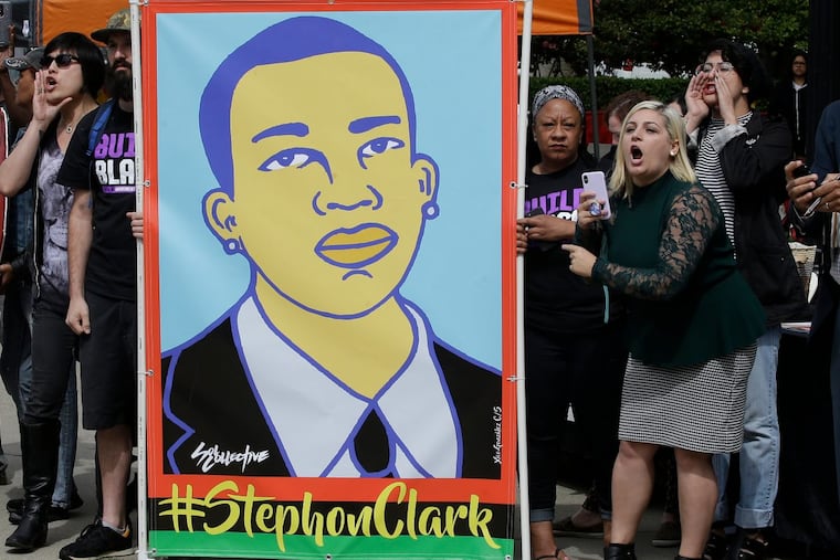 Protesters at an April 9 victims rights rally in Sacramento, Calif., display an image of Stephon Clark.