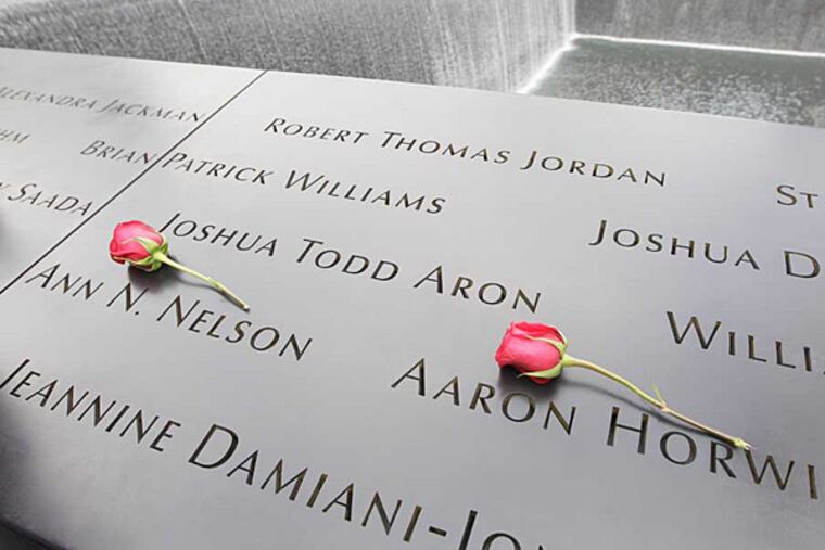 Roses lay on the north pool placed by Dawn Nelson in memory of her sister Ann N. Nelson and Aaron Horwitz at the National September 11 Memorial during a ceremony marking the 10th anniversary of the attacks at World Trade Center, Sunday, Sept. 11, 2011 in New York. (AP Photo/Mary Altaffer)