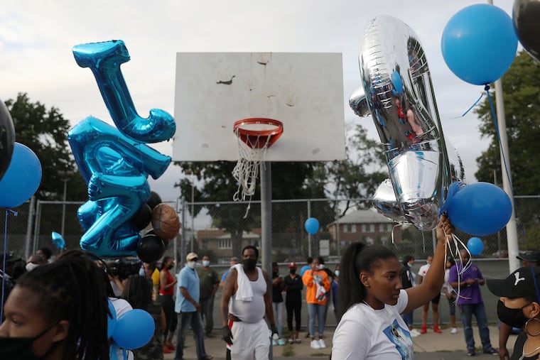 Jaylah Robinson holds balloons before a vigil for her sister Jasmine Lewis at Sturgis Playground in Philadelphia's East Oak Lane section on Tuesday, Sept. 1, 2020. Lewis, 20, was shot and killed Aug. 27.