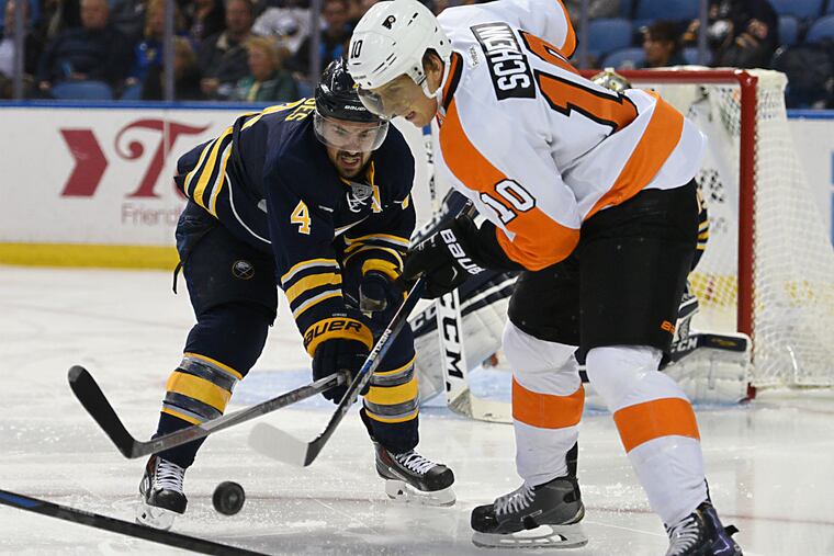 Sabres defenseman Josh Gorges battles for the puck with
Flyers center Brayden Schenn .