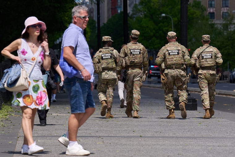 Members of the Florida National Guard pass by tourists on a sidewalk Friday April 17, 2026, in Washington.