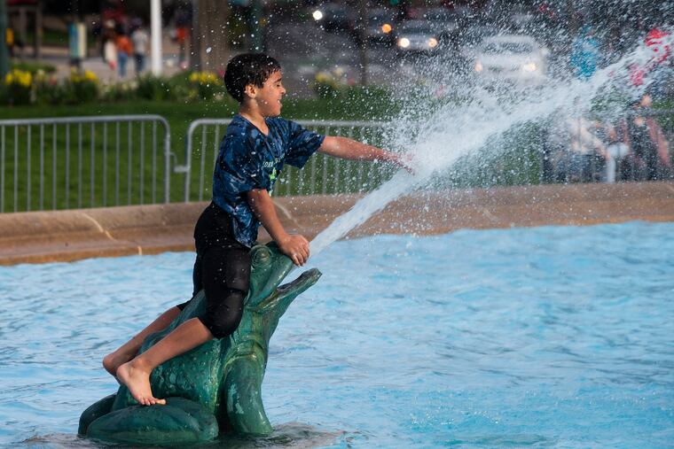A boy cools off at the Swann Memorial Fountain at Logan’s Circle during a warm spell in April. The next few days are going to feel like June and July.