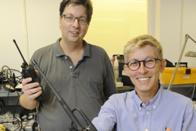 Sandy Clark (foreground), a Ph. D. graduate student in University of Penn's Computer and Information Sciences program, and Matt Blaze, Director of the Distributive Systems Lab, hold P25 two-way radios in their lab. (Clem Murray / Staff Photographer)