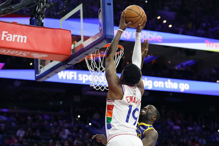 Justin Edwards of the Sixers dunks over Golden State Warriors forward Draymond Green on Saturday.