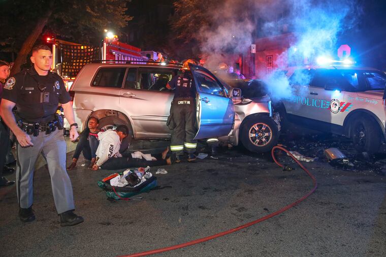 Suburban police chasing robbery suspects car made contact with a Route 31 Septa bus at 37th and Spring Garden. Septa says nine people were injured, one critically, in the 10:04 p.m. accident. Handcuffed suspects sit on the ground at the rear of the car. Tuesday, September 3, 2019.