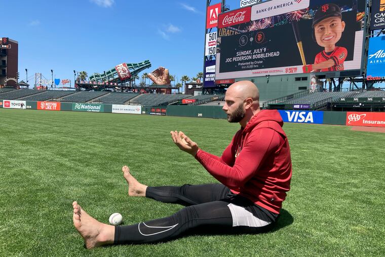 Arizona Diamondbacks first baseman Christian Walker warms up barefoot on the field before a game against the San Francisco Giants in June. “The science of grounding is harnessing the earth’s energy,” says Walker, a former standout at Kennedy-Kenrick High.