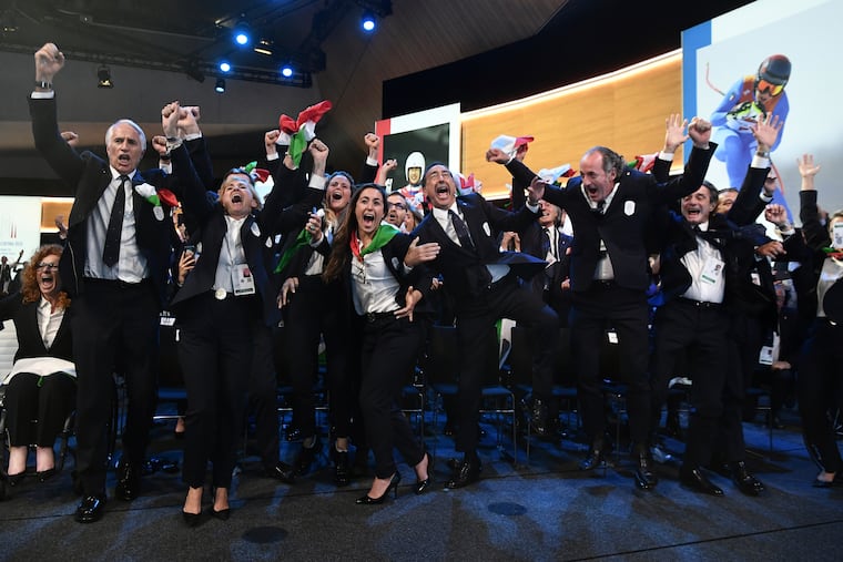Italy's National Olympic Committee celebrates after winning the bid to host the 2026 Winter Olympic Games.