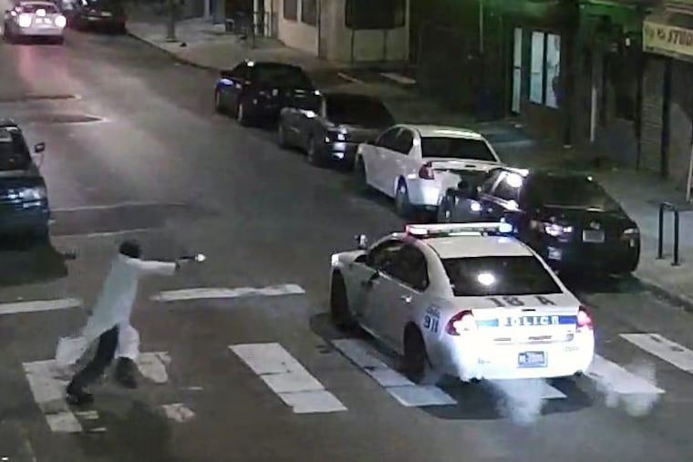 In this Jan. 7, 2016, image made from a video provided by the Philadelphia Police Department, a gunman runs toward a police car driven by Philadelphia Police Officer Jesse Hartnett in Philadelphia.