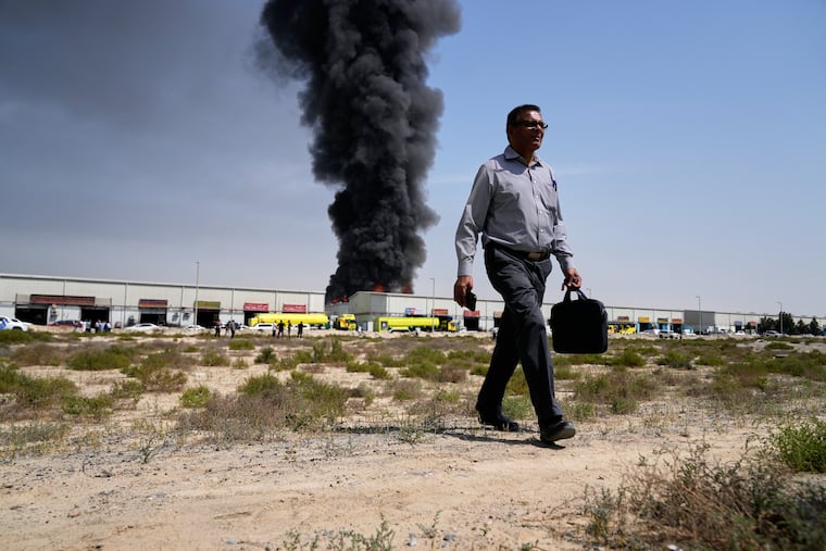 A black plume of smoke rises from a warehouse in the industrial area of Sharjah City, United Arab Emirates, Sunday, March 1, 2026, following reports of Iranian strikes in Dubai.