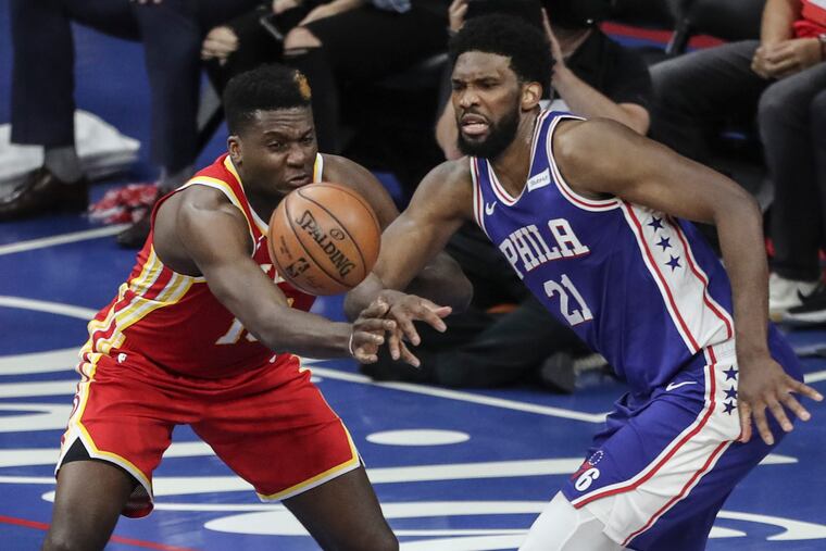 The Sixers' Joel Embiid eyes a loose ball with the Hawks' Clint Capela during the third quarter of Game 5.