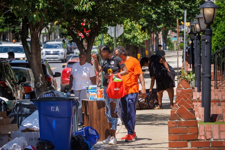 Fatima Frager (front) and her husband Ronald King browse items left out with the trash near the University of Pennsylvania on Wednesday.