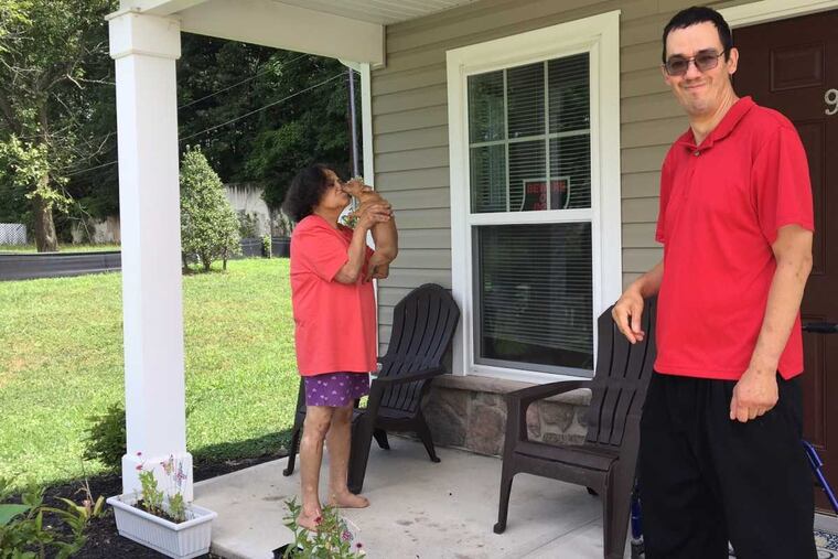Eliza Echevarria and her son, Luis Lopez, enjoying the porch of their new condominium one year after they were offered a "replacement home" in the Mount Holly Gardens following a housing bias lawsuit.