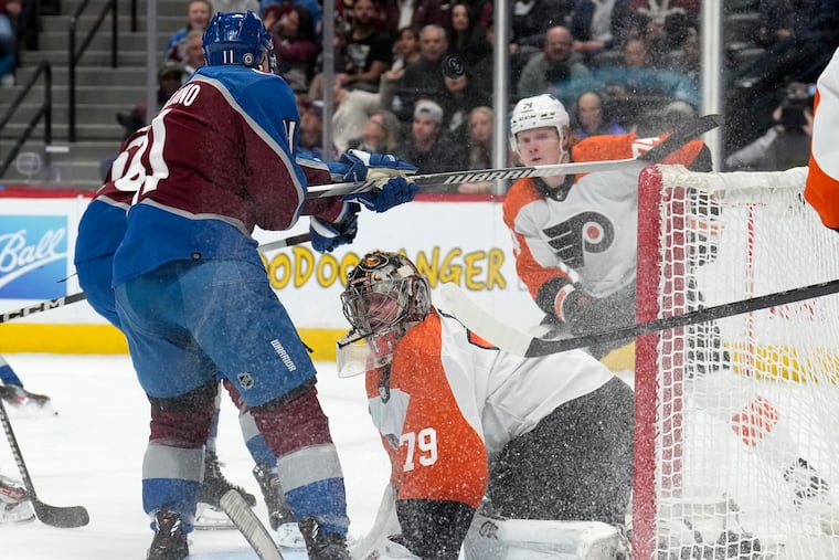 Colorado Avalanche center Andrew Cogliano swings his stick over Flyers goaltender Carter Hart after Hart's save in the first period Saturday.