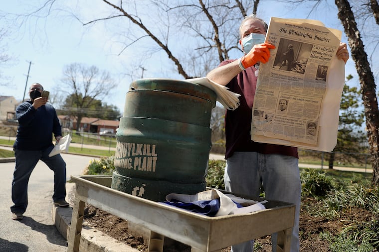 Fred Lehman, vice president of operations, holds a copy of the Sept. 25, 1992, Inquirer newspaper as he opens a time capsule buried in 1992 at The Inquirer's Schuylkill Printing Plant in Upper Merion Township. The time capsule, originally scheduled to be opened in 2092, was opened early because the newspaper is shuttering the plant and outsourcing printing to a Gannett facility in Cherry Hill.