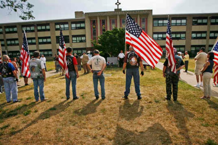 Members of Warriors' Watch Riders stand at attention during a ceremony in front of Cardinal Dougherty High School. The school's Vietnam memorial was moved to the nearby VFW.