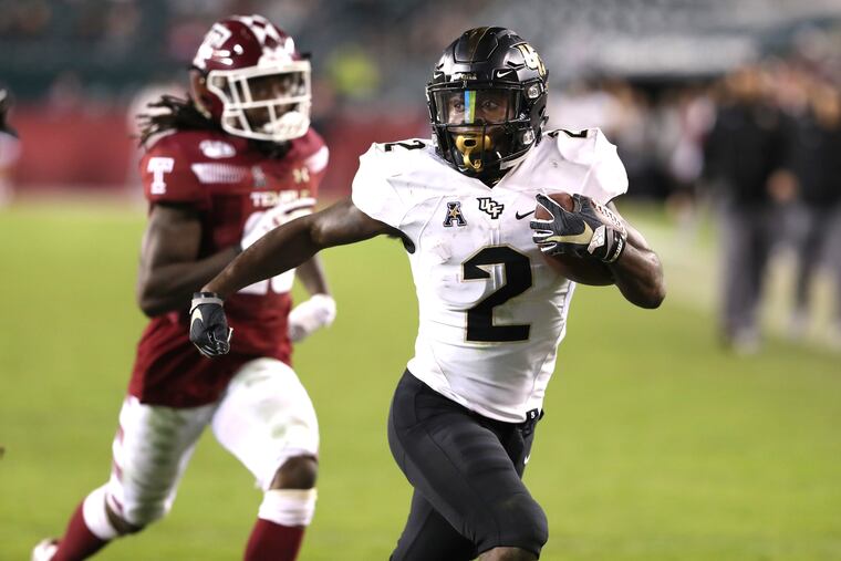 Otis Anderson, right, of Central Florida scoring on a long touchdown run against Temple on Saturday. The Owls' Harrison Hand was in pursuit.