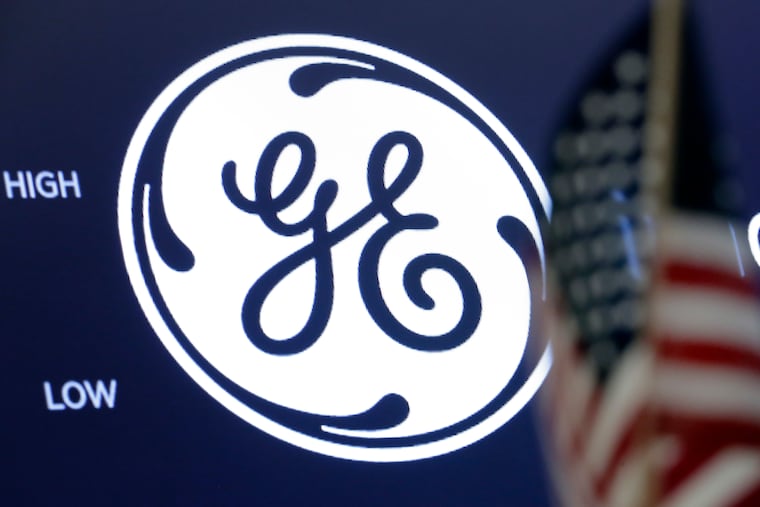 The General Electric logo appears above a trading post on the floor of the New York Stock Exchange.