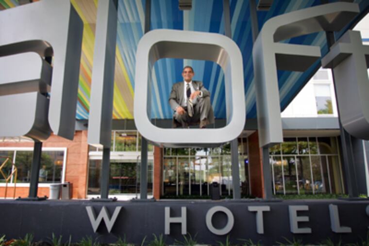 Aloft General Manager Patrick Sanchez is photographed in the logo in front of the new hotel. (DAVID SWANSON / Inquirer)
