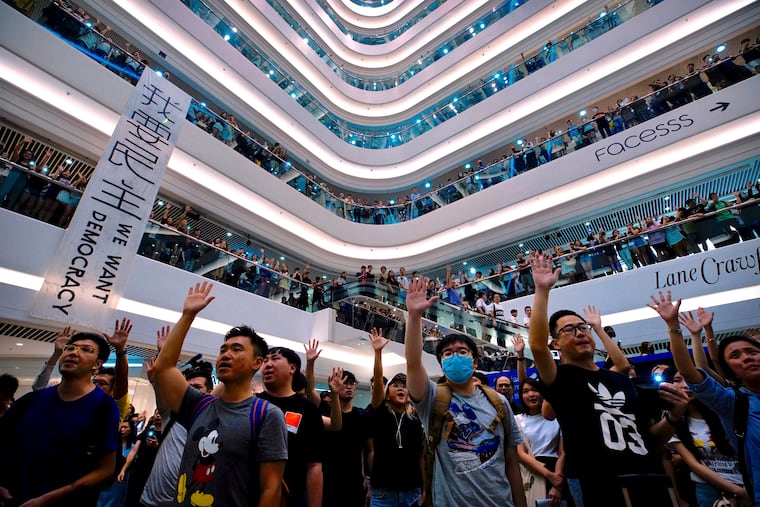 Demonstrators sing a theme song written by protestors "Glory to Hong Kong" at the Times Square shopping mall in Hong Kong, Thursday, Sept. 12, 2019. Thousands of people belted out a new protest song at Hong Kong's shopping malls, continuing a months-long fight for democratic freedoms in the semi-autonomous Chinese territory.