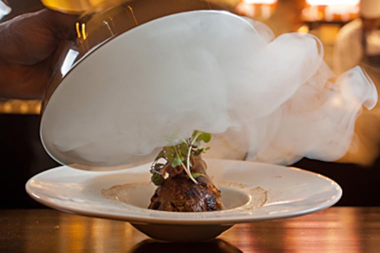 Shikaari quail arrives under a silver bell in a puff of scented smoke. (David M Warren / Staff Photographer)