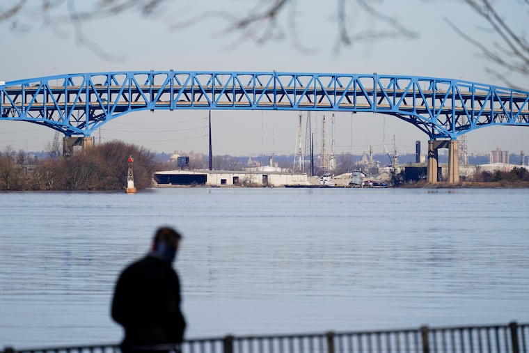 A pedestrian walks past I-95′s double-decked Girard Point Bridge in 2021.