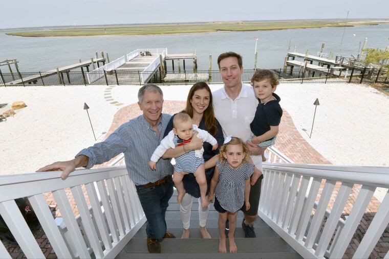 “It doesn’t get much better than sitting bayfront with family and friends on a summer night,” says Kevin Field, who designed a new home on the motel site after Hurricane Sandy damaged the buildings. Now it’s a retreat for the Field family (from left): Andy; Beth holding Drew, Kevin holding Cooper, and Gray (in front).