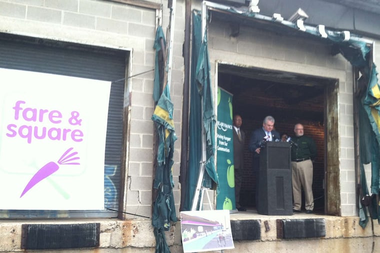 U.S. Rep. Bob Brady at a lectern on the loading dock of a closed supermarket in Chester City, the site of a new market.