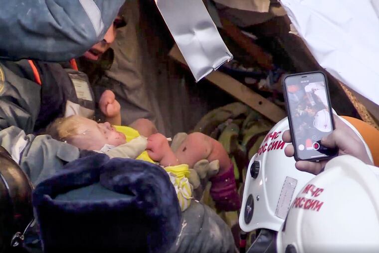 This photo provided by the Russian Emergency Situations Ministry taken from tv footage shows Emergency Situations employees save a 10 month old baby at the scene of a collapsed section of an apartment building, in Magnitigorsk, a city of 400,000 about 1,400 kilometers (870 miles) southeast of Moscow, Russia, Tuesday, Jan. 1, 2019. Rescue crews on Tuesday temporarily halted their search through the rubble in the city of Magnitogorsk while workers tried to remove or stabilize sections of the building in danger of collapse. (Russian Ministry for Emergency Situations photo via AP)