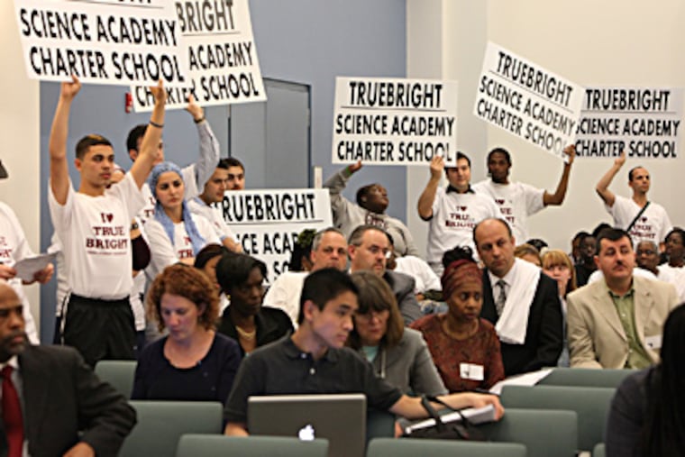 Truebright Science Academy supporters hold their posters high at the SRC hearing. It is one of more than 130 charters nationwide run by followers of a Turkish imam that are drawing scrutiny. (Steven M. Falk / Staff Photographer)